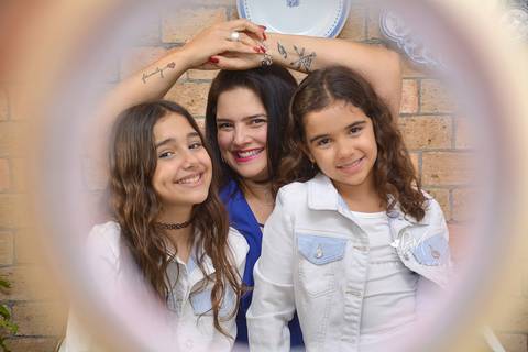 Mãe e filhas em cena de descontraída'