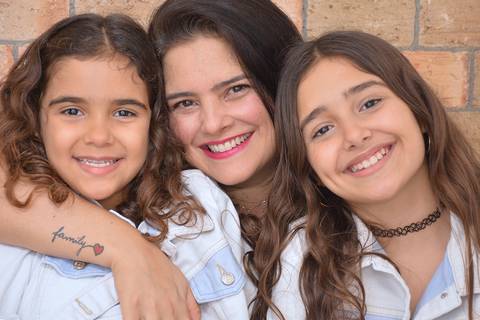 Mãe e filhas em cena de descontraída'