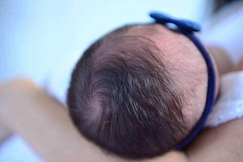 Fotografia em close do redemoinho no cabelo da bebê'