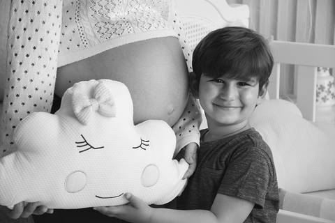 Fotografia pb do filho mais velho ao lado da mamãe gestante'