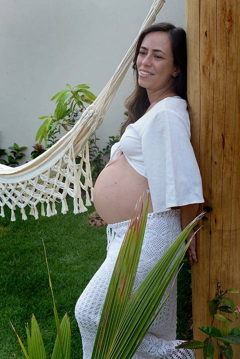 Fotografiada barriga de uma gestante em um jardim'