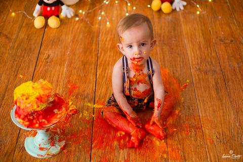 Bebe lambuzado com bolo do smash do mickey'