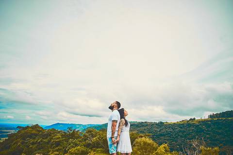 Ensaio pré wedding casal de branco de costas para o outro romântico em vista panorâmica de morro em Botucatu - SP'