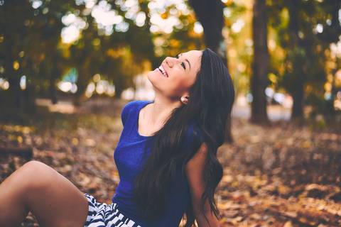 Ensaio feminino de beleza mulher sorri alegre sentada em banco bosque Bauru - SP'