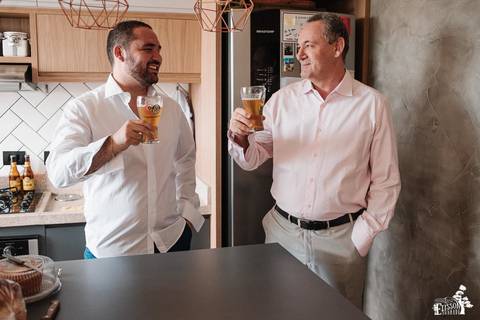 Noivo brindando com o pai no making of'