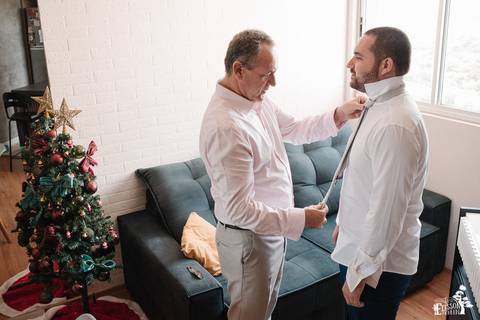 pai ajudando noivo a se arrumar'
