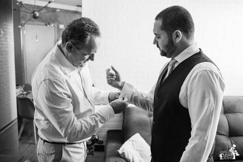 pai ajudando noivo a se arrumar, abotoando a camisa'