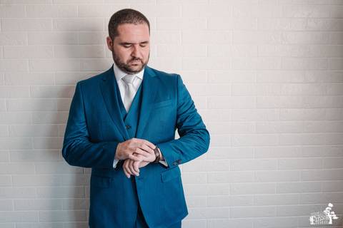 noivo pronto para o casamento olhando as horas no relógio'