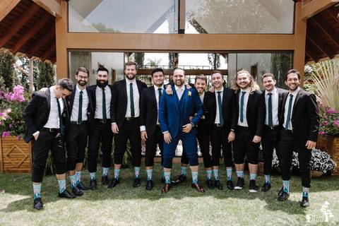 foto de todos os padrinhos usando meia personalizada com o rosto do noivo'