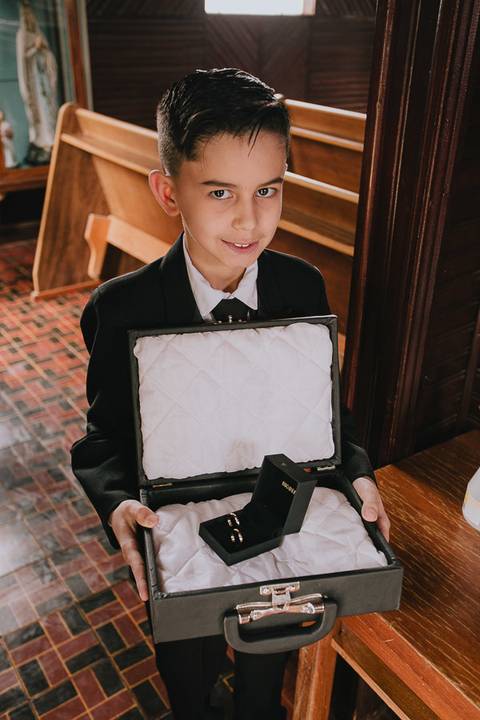 Fotos das alianças dos noivos ainda dentro da caixa, momentos antes da entrada das alianças, seguradas pelo pajem'