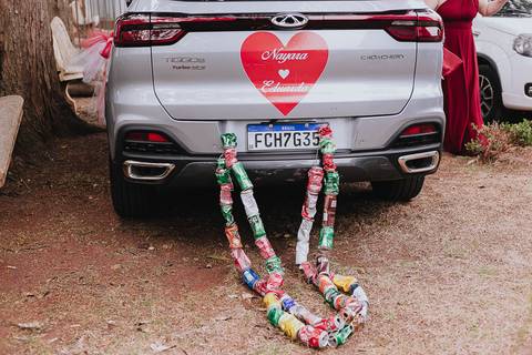 Foto do carro dos noivos com latinhas presas ao carro'
