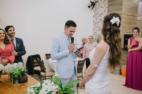 Foto do casamento civil no Espaço Atlanta, durante os votos do noivo, com a noiva sorrindo muito'