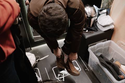 Namorado calçando o sapato de couro. '