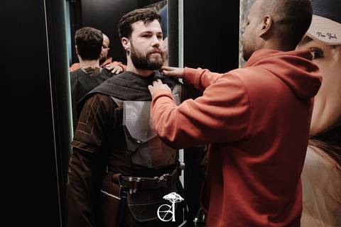 Amigo ajustando a capa de costas para o espelho.'