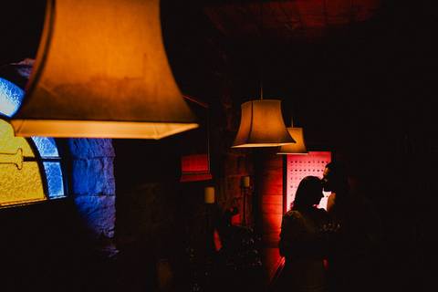 Ensaio fotográfico de casal em silhueta na Vinícola La Dorni em Bandeirantes, PR, cena romântica em ambiente rústico e iluminado, foto artística de fotógrafo de casamentos cristãos.'