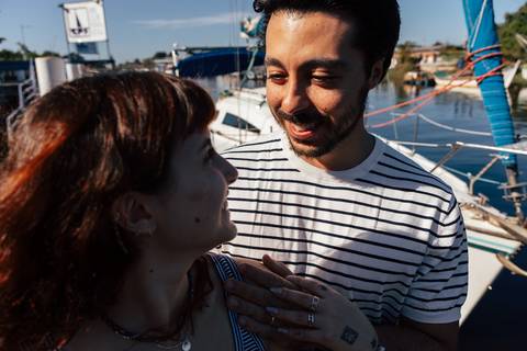 Retrato de perto do casal sorrindo, mão de Mari sobre o peito de Arthur, durante pré-wedding no Iate Clube Pontal do Sul'