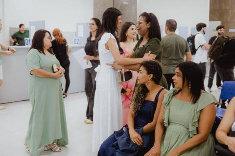 Noiva abraçando uma parente mais velha, sorrindo, no saguão do cartório'