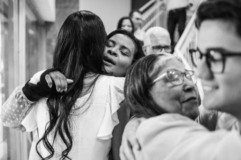 Fotografia em preto e branco de Thamires abracando emocionada uma parente'