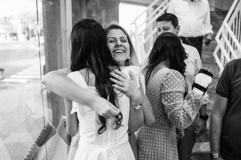 Fotografia em preto e branco de Thamires abracando uma parente, sorrindo'