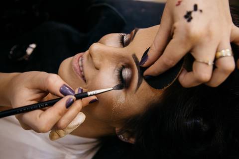 Foto do making of da noiva, enquanto faz maquiagem dos olhos'