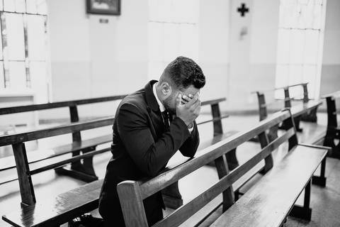 Casamento duplo, de gêmeas, noivo ajoelhado rezando antes do casamento'