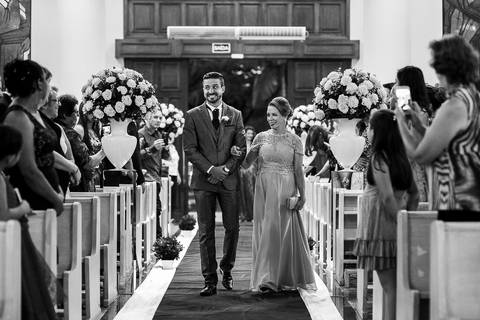 fotos da cerimônia de casamento, com noivo entrando na igreja junto com a mãe'