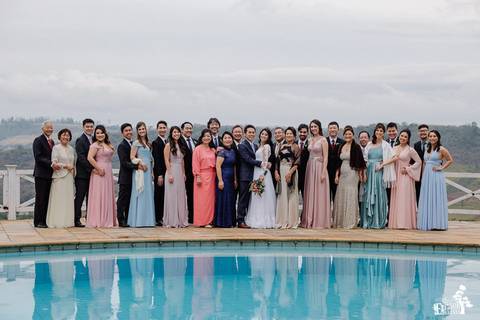 Fotografia de Casamento Boho no Moress Fazenda, Londrina, de fotógrafo de casais de Maringá/PR, em dia nublado e com chuva, foto dos noivos com convidados depois da cerimônia'