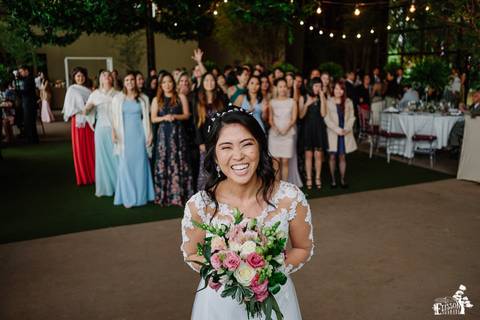 Fotografia de Casamento Boho no Moress Fazenda, Londrina, de fotógrafo de casais de Maringá/PR, em dia nublado e com chuva, foto da noiva jogando o buquê'