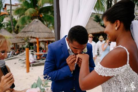 Fotografia de casamento na praia, casamento pé na areia, fotógrafo de Maringá/PR fotografando destination wedding em Cancun, Mexico, noivo beijando a mão da noiva com aliança'