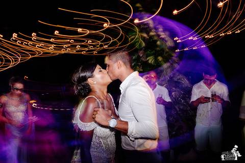 Fotografia de casamento na praia, casamento pé na areia, fotógrafo de Maringá/PR fotografando destination wedding em Cancun, Mexico, durante a festa, com noivos se beijando'