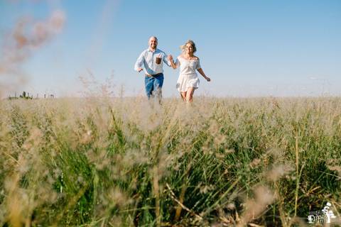 ensaio no campo com casal de noivos, ensaio pré-wedding, casal correndo no campo'