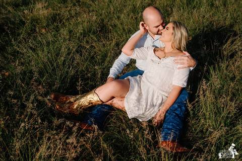 ensaio no campo com casal de noivos, ensaio pré-wedding, casal sentado no campo'