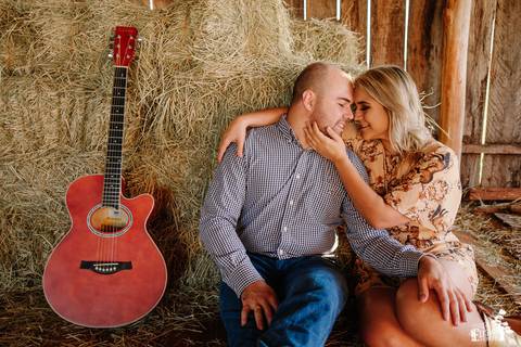 ensaio pré-wedding de casal sertanejo, no campo, foto na fazenda com violão'