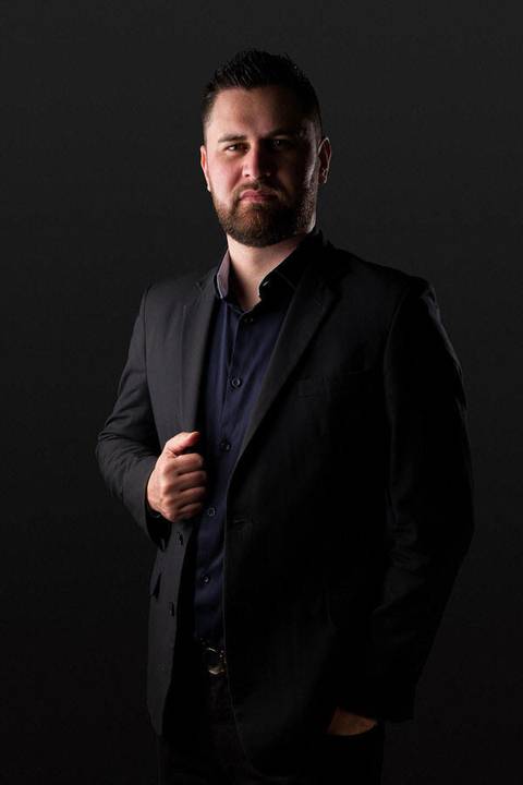 Retrato empresarial ou corporativo de Thiago Damasceno, em estúdio, fundo escuro, preto e cinza e recortado para banners'