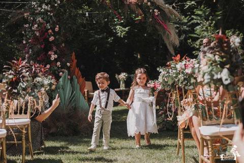 casal de pajens entrando em casamento ao ar livre, durante o dia, no Recanto Paraíso, em Maringá'