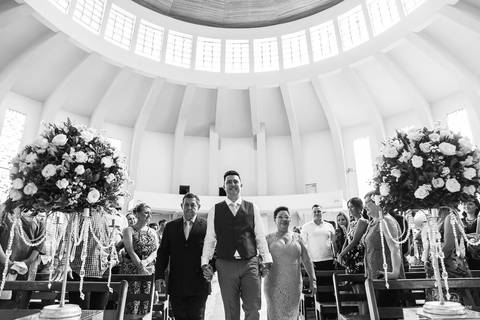 Entrada do noivo na igreja, de mãos dadas com os pais'