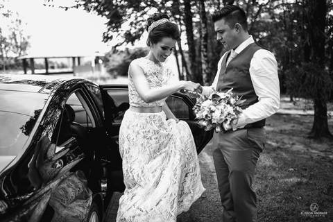 noivo ajudando a noiva a sair do carro antes da festa de casamento'