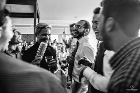 festa de casamento durante o dia, noivo passando de mesa em mesa fazendo a gravata'