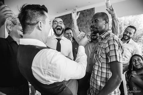 festa de casamento durante o dia, noivo passando de mesa em mesa fazendo a gravata'