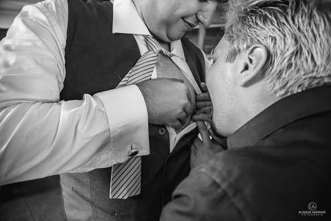 festa de casamento durante o dia, noivo passando de mesa em mesa fazendo a gravata'