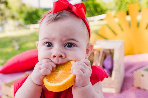 Ensaio de acompanhamento mensal - 6 meses - criança comendo laranja'