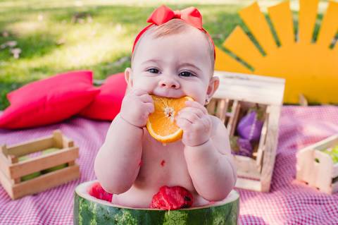 Ensaio de acompanhamento mensal - 6 meses - criança comendo laranja dentro da melancia'