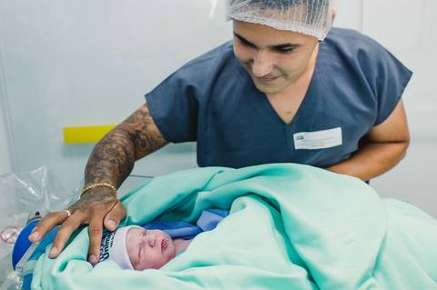Documental de parto - pai fazendo carinho no bebê'