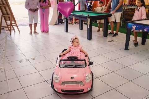 Festa de aniversário infantil - fotógrafa Claudia Wallauer - aniversariante chegando na festa com carro de brinquedo cor de rosa'