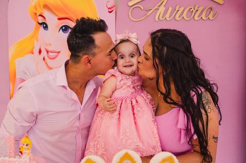 Festa de aniversário infantil - fotógrafa Claudia Wallauer - aniversariante - ganhando um beijinho dos pais na mesa decorada das princesas'