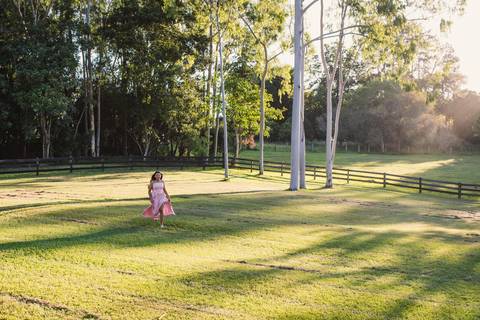 Ensaio de 15 anos, menina correndo pelo campo verde, sol do final de tarde'