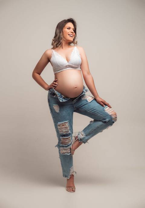 FOTO DE GESTANTE COM CALÇA JEANS E TOP BRANCO'