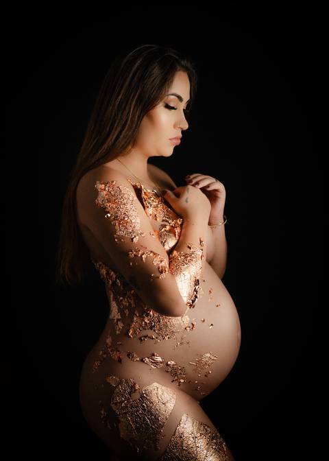 Foto de gestante com folha dourada'