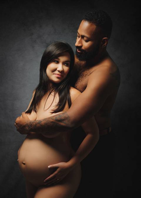 foto gestante com marido segurando seio '