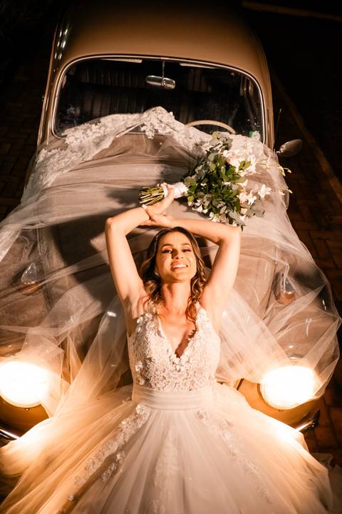 noiva no fusca com vestido e buque '